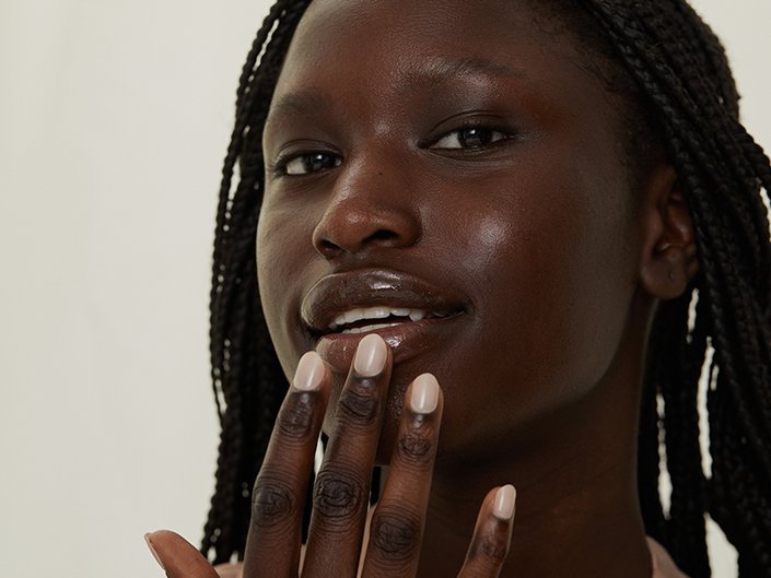 Close-up picture of a model touching their bottom lip