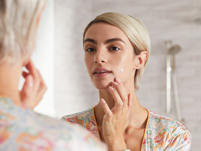 Picture of a person putting spot treatment on their chin
