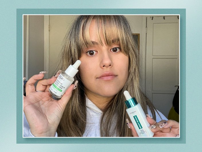 Editor holding up the L’Oréal Paris Bright Reveal 12% Niacinamide Dark Spot Serum and the Kiehl’s Ultra Pure High-Potency 5.0% Niacinamide Serum